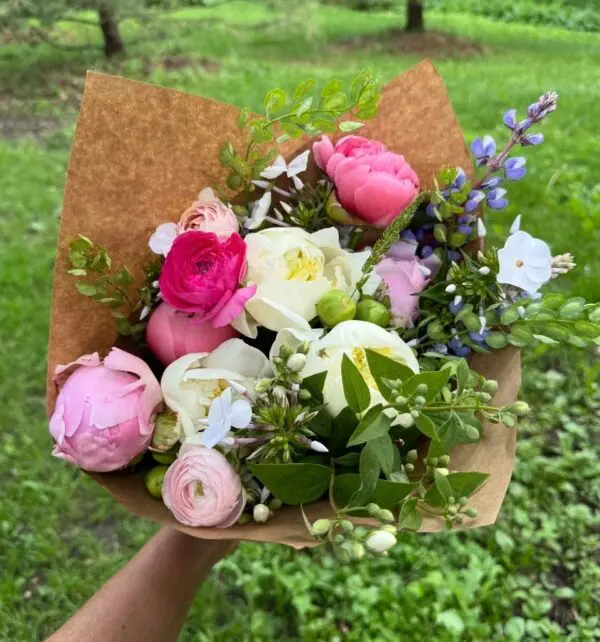 Hand holding colorful spring flower bouquet