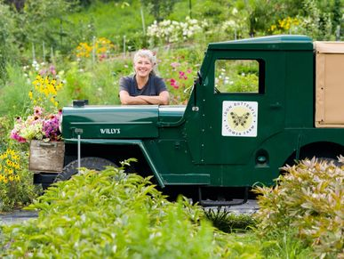 Smiling woman beside green vintage vehicle