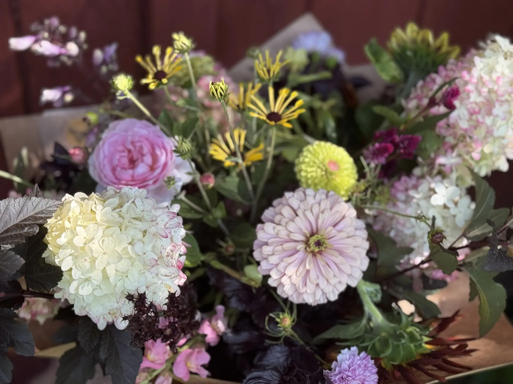 A vibrant bouquet featuring white, purple, and yellow flowers with greenery.