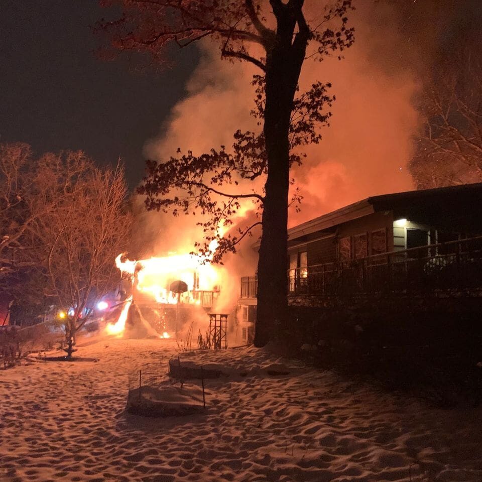 Winter night house fire with smoke billowing